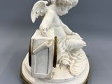 an antique figurine of a cupid sitting on top of a box