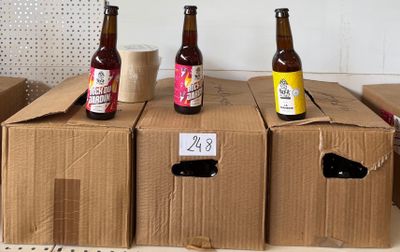 trois bouteilles de bière sont posées sur des cartons dans une pièce