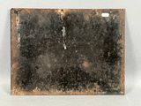an old rusted metal plate sitting on top of a white surface