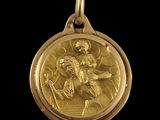 an image of a gold medal with a saint on it