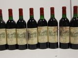 six bottles of red wine lined up in a row on a table