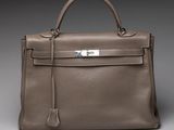 a brown leather handbag on a grey background