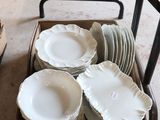 many plates and bowls in a box on the floor