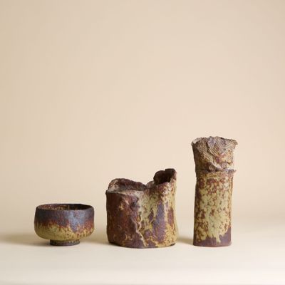 trois pièces de poterie posées sur une table blanche
