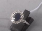 an image of a ring with a blue stone surrounded by diamonds