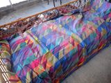 a bed with a colorful quilt on it in a room