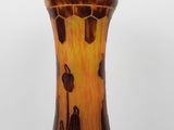 a brown and black vase sitting on a table