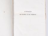 an open book sitting on top of a white table next to a pair of scissors