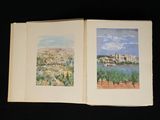 an open book with two pictures of a city and a lake