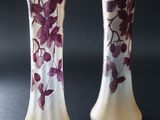 des vases violets et blancs ornés de fleurs violettes, posés sur un fond noir