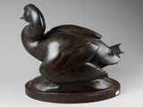 bronze sculpture of a duck on a wooden base on a white background