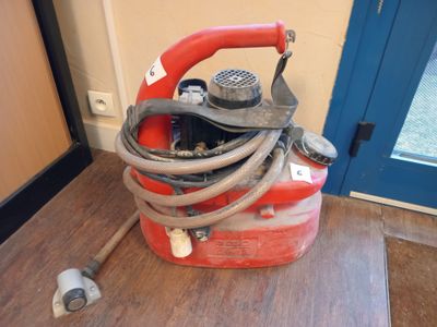 an image of a red and white hose and a red canister on a wooden floor