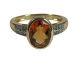 an image of a gold ring with a brown stone surrounded by diamonds