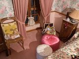une pièce avec un lit, une chaise et une fenêtre avec des rideaux