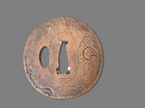 a close up of a metal plate with a bird on it
