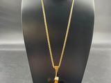 a gold cross pendant with a chain on a mannequin