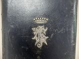 an old book with a crown on it sitting on top of a table