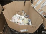 une boîte en carton remplie d'objets divers, posée par terre