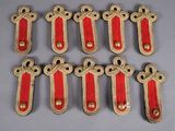 six pairs of red and gold military badges on a gray surface