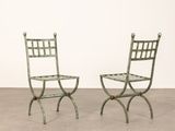pair of green metal chairs in the shape of a folding chair
