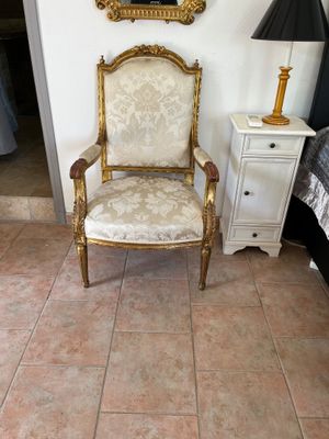 une chaise dans un coin d'une pièce où se trouve un miroir accroché au mur