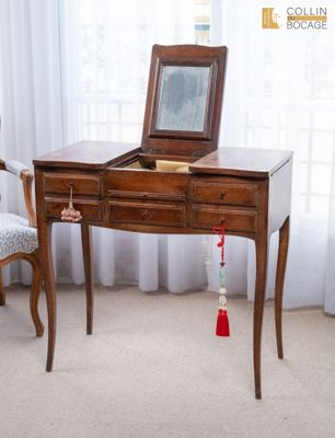 un petit bureau en bois sur lequel est posé un miroir
