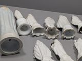 a lot of white ceramic objects on a table