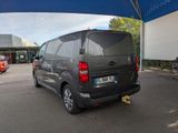 a grey van parked under a blue umbrella in a parking lot