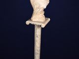 a white marble busturine of a woman on a pedestal