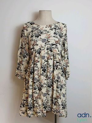 a dress on a mannequin stand in front of a white wall