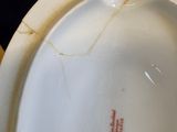 a close up of a white vase with a red line on it