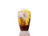 a yellow vase with flowers on it sitting on a table