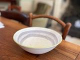 un bol posé sur une table en bois devant une cheminée