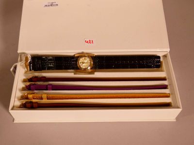 a box that has a watch, pen, pencil, and other items in it