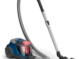 un aspirateur bleu et argent muni d'un tuyau, sur fond blanc