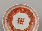 une assiette orange et blanche ornée d'un motif floral