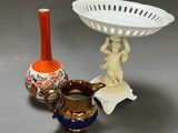 three vases and a bowl sitting on a table