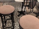 three stools and a table in a room with a rug on the floor