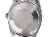 a silver watch that is sitting on a white surface