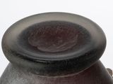 a black vase sitting on a table with a white background