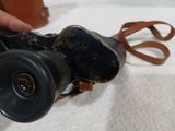 a person holding a camera with a strap around it
