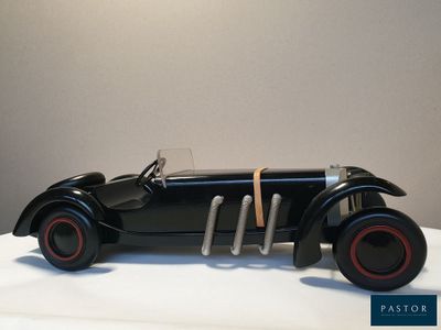 une petite voiture noire posée sur une table blanche