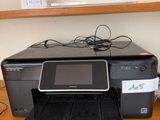 a printer sitting on top of a desk next to a cell phone