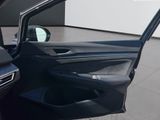the interior of a car with the door open and the driver ' s seat down