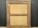 an old wooden frame sitting on top of a wooden floor next to a black wall