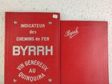 two red books sitting next to each other on a white surface