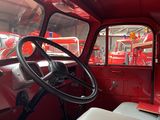 a red truck with a steering wheel in the back of it
