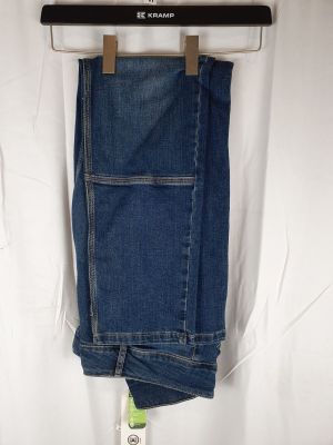 le jean est suspendu à un cintre sur un drap blanc