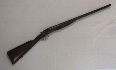 a rifle that is laying on a white sheet on a table