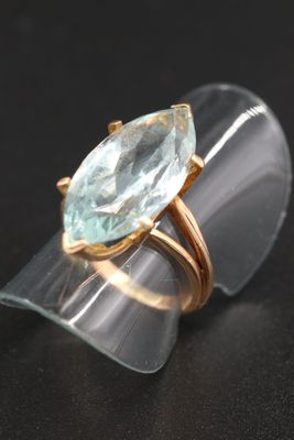un gros plan d'une bague sertie d'une aigue-marine sur un fond noir